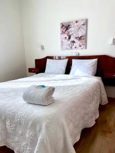 a white bed with a towel on top of it at Residencial Moderna in Torres Vedras