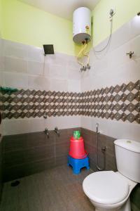 a bathroom with a toilet and a red stool at PRIMES RESIDENCY in Kālapettai