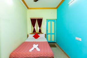 a small bedroom with a red bed with two white shoes at PRIMES RESIDENCY in Kālapettai