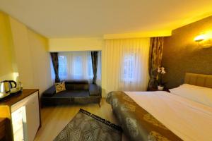 een hotelkamer met een bed en een bank bij La Boutique Atlantik Hotel in Tekirdag