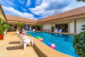 - une piscine avec des chaises et des balles dans une maison dans l'établissement Siam Court Hotel and Resort, à Bang Sare