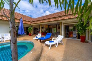 a patio with chairs and a pool and a house at Siam Court Hotel and Resort in Bang Sare