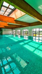 una piscina vacía con techo y ventanas en Fabryka Wełny Hotel & Spa, en Pabianice