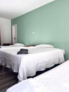 two beds with white sheets in a room at Residencial Moderna in Torres Vedras