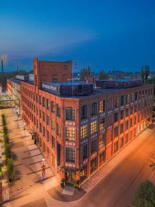 a large brick building on a city street at night at Fabryka Wełny Hotel & Spa in Pabianice