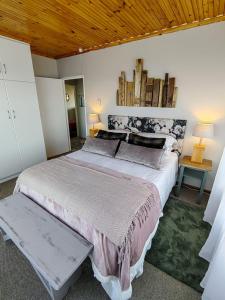 a bedroom with a large bed and a wooden ceiling at The Nightingale in Groot Brak Rivier
