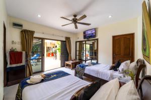 a room with three beds and a ceiling fan at Siam Court Hotel and Resort in Bang Sare