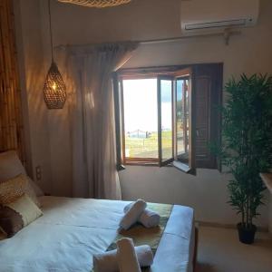 a bedroom with a large bed with a window at Acqua Blue Mola Kaliva resort in Mola Kalyva