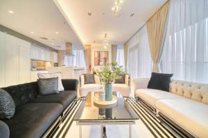 a living room with two couches and a table at Livbnb - Elegant 3BR+Maid, Sea View in Bluewaters in Dubai