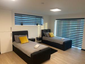 a living room with two beds and two windows at Pinchbeck B&B in Pinchbeck