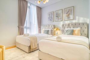 a bedroom with two beds and a large window at Livbnb - Elegant 3BR+Maid, Sea View in Bluewaters in Dubai