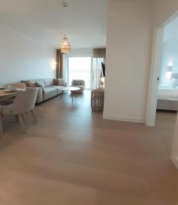 a living room with a couch and a table at Polanki Aqua Nature View in Kołobrzeg +17 photos