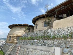 uma casa no topo de uma parede de pedra em Cameron Highlands Blueberry Earth House em Cameron Highlands