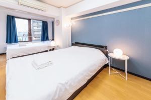a bedroom with two beds and a blue wall at Yotsuya Matsumoto Hotel in Tokyo