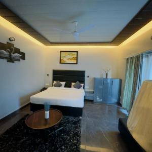 um quarto de hotel com uma cama e uma mesa em THE NINE RESORT em Bhimtal