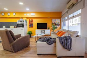 ein Wohnzimmer mit 2 Sofas und einem TV in der Unterkunft Orange loft en el corazon de Girona in Girona