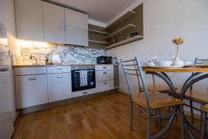a kitchen with white cabinets and a table and chairs at Beautiful and spacious 2-Bed Apartment in London in London