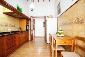 uma cozinha com armários de madeira e uma mesa de madeira em Can Cirerol em Porto Colom