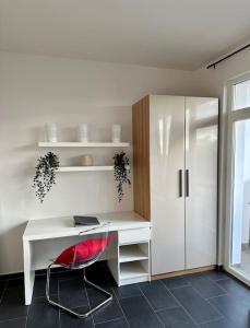 a white desk with a red chair in a room at Apartment in zentraler Lage (mit Arbeitsecke) in Krefeld