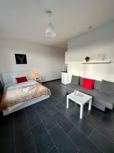 a bedroom with a bed and a couch and a table at Apartment in zentraler Lage (mit Arbeitsecke) in Krefeld