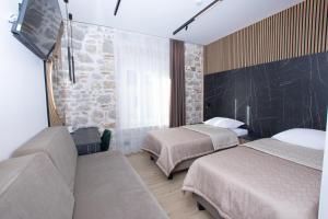 a hotel room with two beds and a couch at A Heritage Split in Split