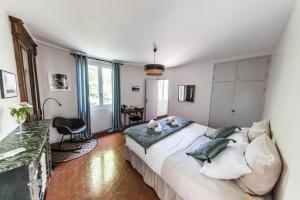 sypialnia z dużym łóżkiem, stołem i krzesłami w obiekcie La Demoiselle w Awinionie