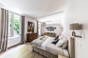 een witte slaapkamer met een groot bed en een raam bij La Demoiselle in Avignon