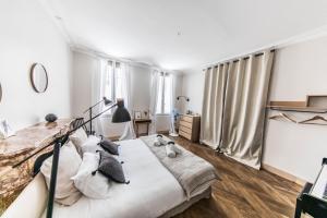 a bedroom with a large bed with white sheets and pillows at La Demoiselle in Avignon