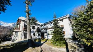 a large white house with a tree in front of it at Residence Villa Linda in Bardonecchia