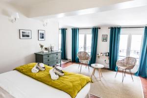 sypialnia z niebieskimi zasłonami, łóżkiem i biurkiem w obiekcie La Demoiselle w Awinionie