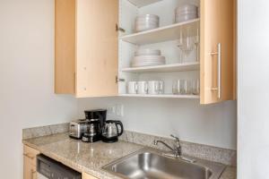 a kitchen with a sink and some cups and dishes at FiDi studio w gym doorman nr Freedom Tower NYC-1097 in New York