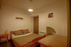 a small bedroom with a bed and a table at Studio Conventionnel Chiappe Vieille ville Ajaccio in Ajaccio