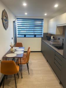 uma cozinha com uma mesa e cadeiras numa cozinha em Pinchbeck B&B em Pinchbeck