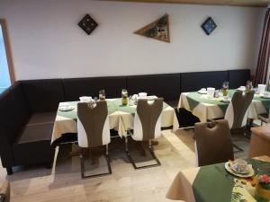 ein Esszimmer mit zwei Tischen mit grün-weißen Tischdecken. in der Unterkunft Hotel Harbauer in Schwarzenbruck
