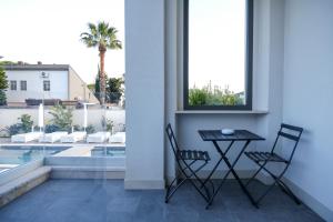 balcón con mesa, sillas y piscina en Dimora Giulia, en Bari