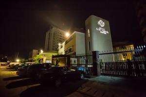 a building with cars parked in a parking lot at night at Hotel Bon Voyage in Lagos