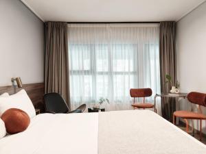 a hotel room with a bed and a window at The Newel Acropolis in Athens