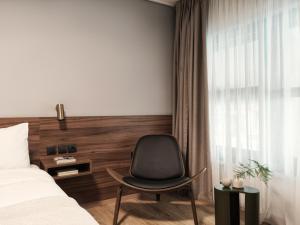 a bedroom with a chair and a bed and a window at The Newel Acropolis in Athens