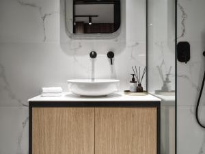 a bathroom with a sink and a mirror at The Newel Acropolis in Athens