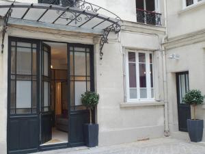 Zugang zu einem Gebäude mit schwarzen Türen und Topfpflanzen in der Unterkunft Saint germain cosy in Paris