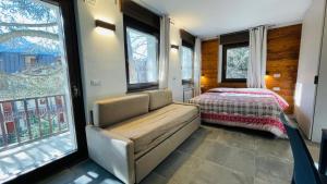a bedroom with a couch and a bed and windows at Residence Villa Linda in Bardonecchia