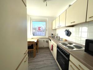 a kitchen with white cabinets and a stove top oven at Free Parking - 2 Schlafzimmer Apart mit 3 Betten in Pforzheim