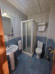 y baño con ducha, aseo y lavamanos. en Hostal Talavera en Talavera la Real