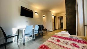 Pokój z łóżkiem, stołem i krzesłami w obiekcie Residence Villa Linda w mieście Bardonecchia