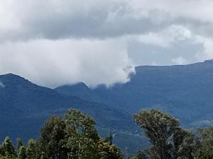 a view of a mountain range with clouds and trees at MT. KENYA PALACE in Nyeri
