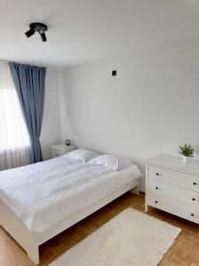 a white bedroom with a white bed and a white dresser at Cosy apartment in Ghent in Ghent