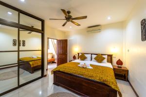 a bedroom with a bed and a mirror at Siam Court Hotel and Resort in Bang Sare +82 photos