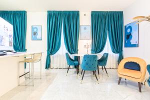 a dining room with blue chairs and a table at Monte Napoleone Split-level Terrace Apartment - Top Collection in Milan