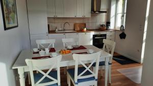 a kitchen with a table and chairs with a bowl of fruit at 1a Ferienwohnung Poel in Kirchdorf