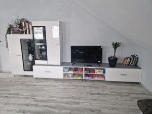 ein Wohnzimmer mit einem TV auf einem weißen Entertainment-Center in der Unterkunft Ferienwohnung Schusi Kesselsdorf in Kesselsdorf